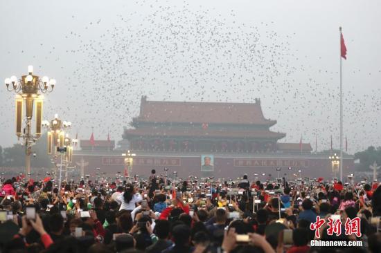 资料图：数万民众在北京天安门广场观看国庆升旗仪式。记者 盛佳鹏 摄